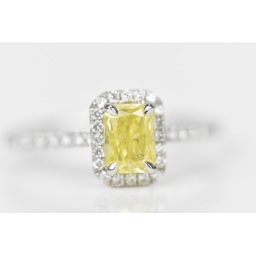 181 - A fancy intense yellow diamond and diamond cluster ring, the cut corner rectangular modern brilliant... 