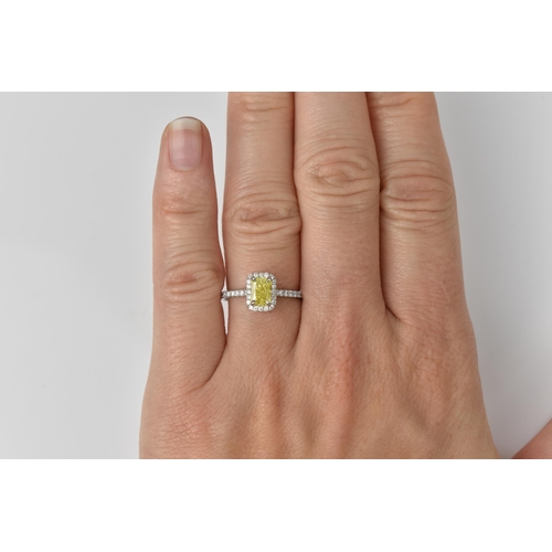 181 - A fancy intense yellow diamond and diamond cluster ring, the cut corner rectangular modern brilliant... 