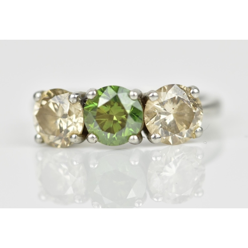 189 - A three stone platinum and diamond ring, with central green diamond, flanked by two similar sized br... 