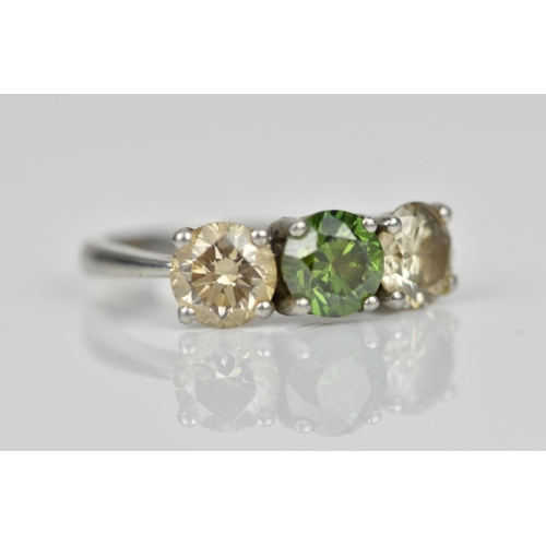 189 - A three stone platinum and diamond ring, with central green diamond, flanked by two similar sized br... 