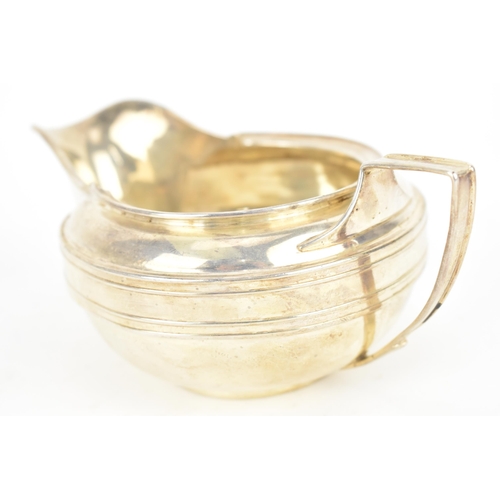 194 - A George III silver creamer by John Emes, London 1807, of squat circular form with moulded lip, on a... 