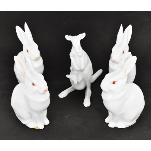 115 - A group of four Herend porcelain albino rabbits, each in white glaze with red eyes, in a seated posi... 