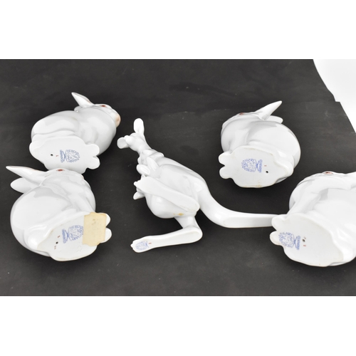 115 - A group of four Herend porcelain albino rabbits, each in white glaze with red eyes, in a seated posi... 