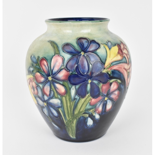 132 - A Walter Moorcroft pottery vase in the 'Spring flowers' pattern, of baluster form with tube-lined bl... 