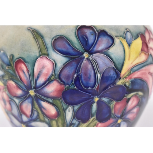 132 - A Walter Moorcroft pottery vase in the 'Spring flowers' pattern, of baluster form with tube-lined bl... 