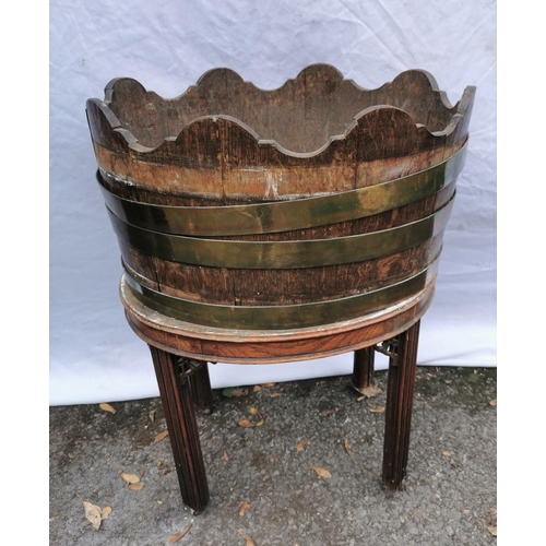 163 - A Georgian mahogany brass bound wine cooler, of oval form in the style of a barrel with waved rim, o... 