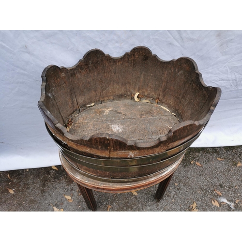 163 - A Georgian mahogany brass bound wine cooler, of oval form in the style of a barrel with waved rim, o... 