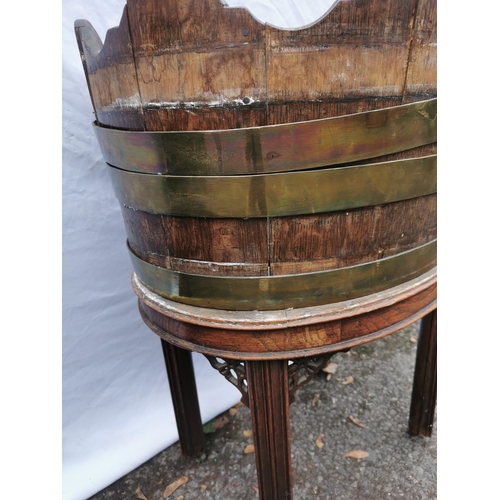 163 - A Georgian mahogany brass bound wine cooler, of oval form in the style of a barrel with waved rim, o... 