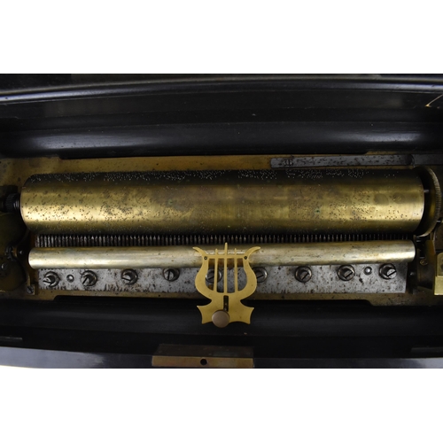 215 - A late 19th century inlaid cylinder music box, playing eight airs, the brass cylinder with graduated... 