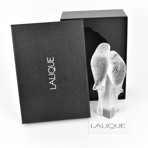 39 - A Lalique crystal model of two parakeets, modelled in frosted and clear glass, the two birds perched... 