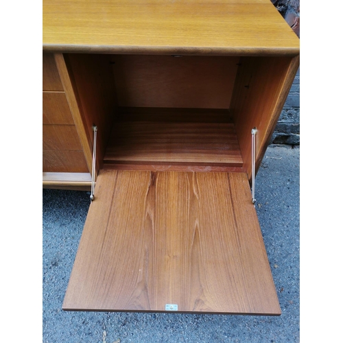 52 - A mid-century G-Plan Brasilia teak sideboard, fitted with four central drawers, the top one with cut... 