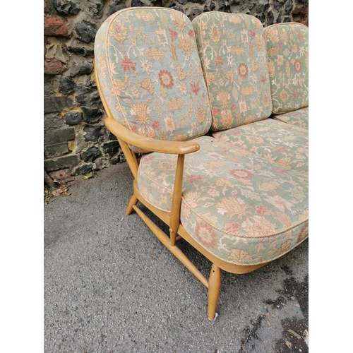 56 - An Ercol stained beech three seater sofa, with upholstered squab cushions, 174 cm wide x 76 cm high