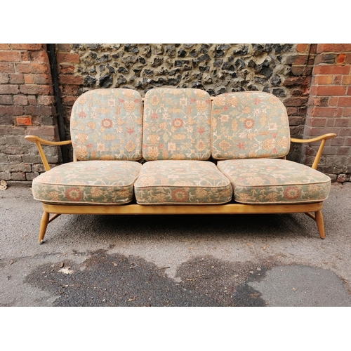 56 - An Ercol stained beech three seater sofa, with upholstered squab cushions, 174 cm wide x 76 cm high