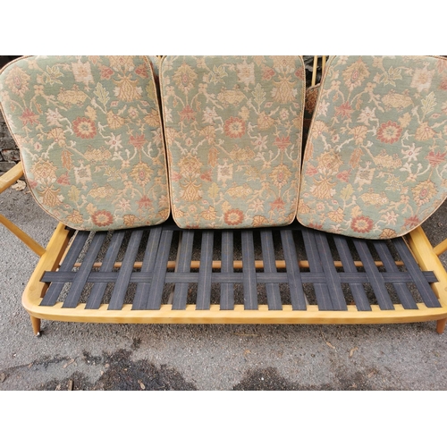 56 - An Ercol stained beech three seater sofa, with upholstered squab cushions, 174 cm wide x 76 cm high