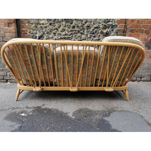 56 - An Ercol stained beech three seater sofa, with upholstered squab cushions, 174 cm wide x 76 cm high