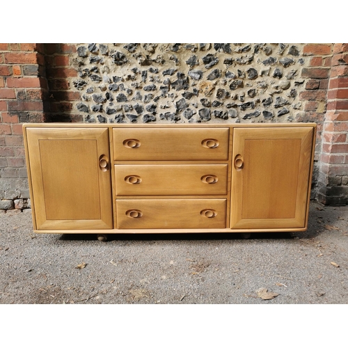 57 - An Ercol 455 light elm sideboard, of rectangular form with central top cutlery drawer above two othe... 