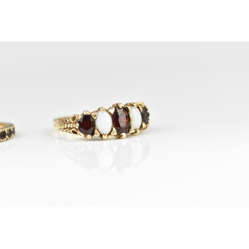 127 - A small group of dress rings, to include a 9ct yellow gold, garnet and white opal five stone ring, a... 