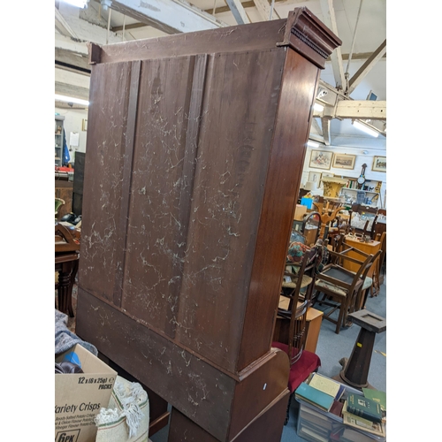 220 - An early 20th century mahogany bookcase having a dental moulded cornice above twin glazed doors, rol... 