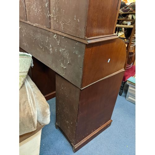 220 - An early 20th century mahogany bookcase having a dental moulded cornice above twin glazed doors, rol... 