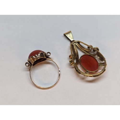 148 - A yellow metal, testing as gold, ring and matching scroll effect pendant, both inset with red coral,... 