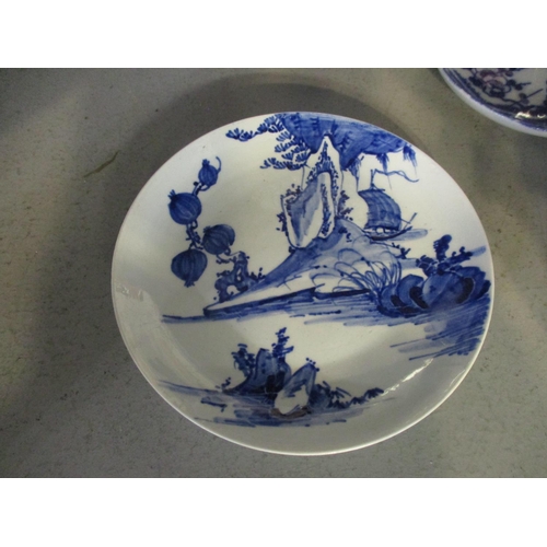 249 - A Chinese porcelain blue and white saucer dish decorated with a sailboat on a river scene with rock ... 