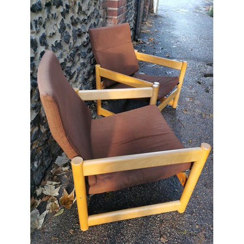 69 - A pair of 1970s beech armchairs, in the Parker Knoll style, the back rest and seat cushion in brown ... 