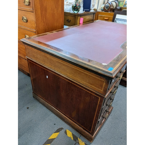 165 - A late 19th/early 20th century mahogany, twin pedestal desk having a red leather topped scriber, inl... 