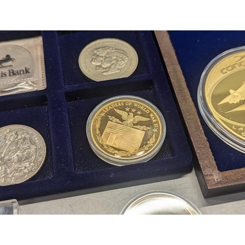 369 - A group of British commemorative coins to include gold plated Concorde and Winston Churchill example... 