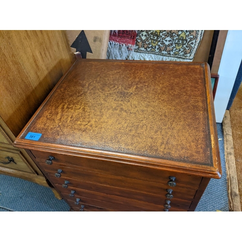 381 - A late 20th century mahogany collectors cabinet with a leather inset top over seven drawers, locked ... 