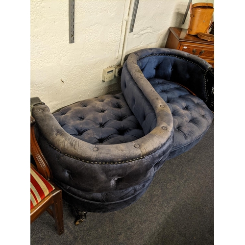 404 - A late 20th century love seat with a black gloss finished frame, button upholstered in blue velvet f... 