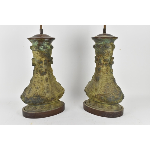 222 - A pair of Chinese heavy bronze lamps in the archaic design, of baluster form supported on wooden bas... 