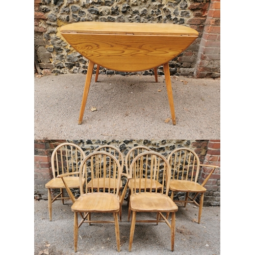 60 - A mid century blonde elm circular drop leaf table together with a set of six Ercol windsor dining ch... 