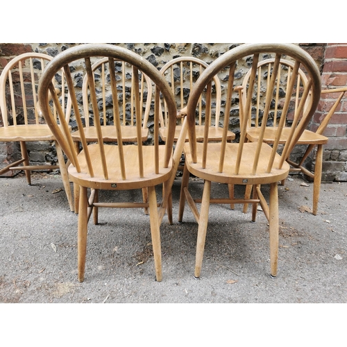 60 - A mid century blonde elm circular drop leaf table together with a set of six Ercol windsor dining ch... 