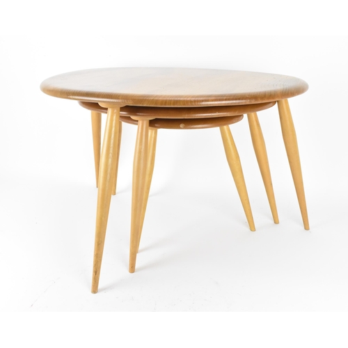 62 - A nest of three Ercol blonde elm pebble tables, model 354, each raised on three turned splayed legs,... 