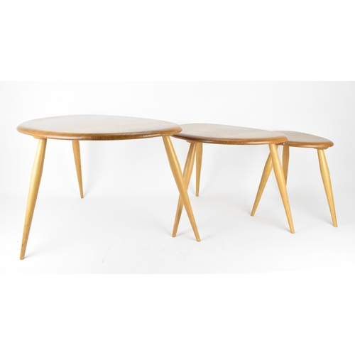 62 - A nest of three Ercol blonde elm pebble tables, model 354, each raised on three turned splayed legs,... 