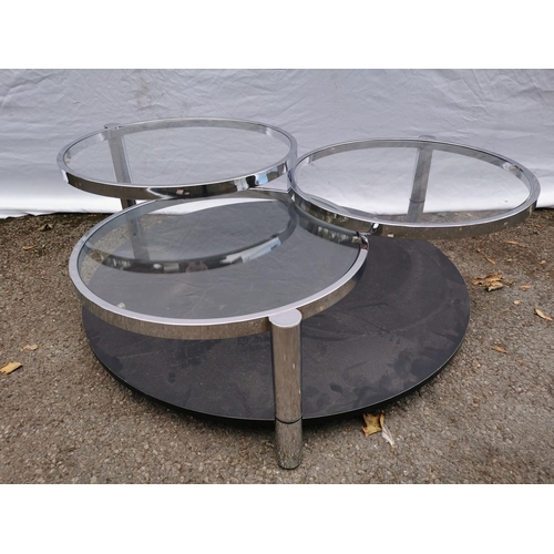 65 - A three-tiered glazed coffee table by Milo Baughman, each circular top with swivel arm, in chrome fr... 