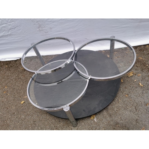 65 - A three-tiered glazed coffee table by Milo Baughman, each circular top with swivel arm, in chrome fr... 