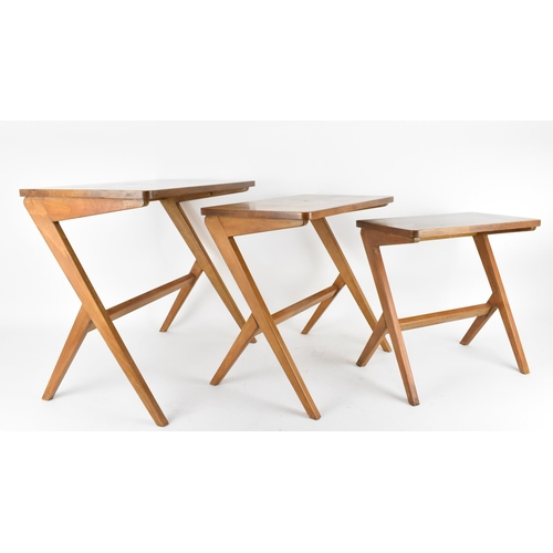 67 - A Swedish nest of three 1950's walnut occasional tables by Bengt Ruda, supported on staggered legs w... 