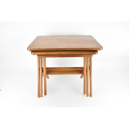 67 - A Swedish nest of three 1950's walnut occasional tables by Bengt Ruda, supported on staggered legs w... 