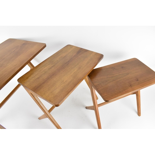 67 - A Swedish nest of three 1950's walnut occasional tables by Bengt Ruda, supported on staggered legs w... 