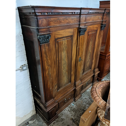 472 - An early 19th century mahogany large German breakfront cabinet with a dentil moulded cornice above a... 