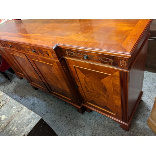 511 - A reproduction mahogany breakfront sideboard having three drawers and four panelled doors, 91cm h x ... 