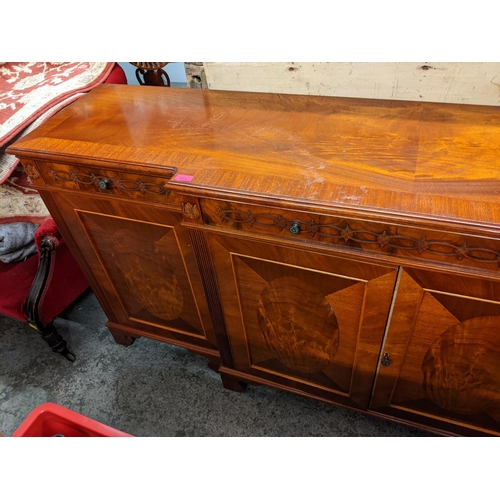 511 - A reproduction mahogany breakfront sideboard having three drawers and four panelled doors, 91cm h x ... 