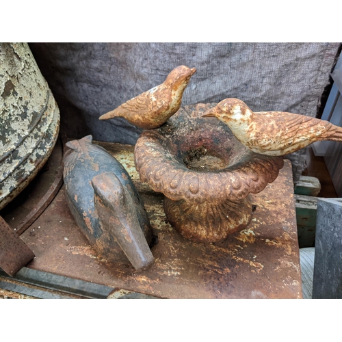 489 - Garden related items to include a metal duck, a small birdbath, a cast metal cauldron on a stand, an... 