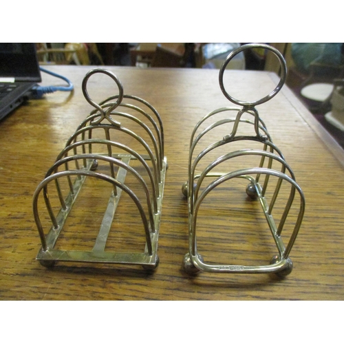 520 - Two silver toast racks, a George V six-compartment toast rack on ball feet, Sheffield 1929 marks for... 