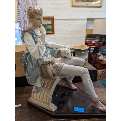 441 - Lladro figure Hamlet, a man sat in a chair with a skull on his knee, on a wooden plinth, 39cm h Loca... 