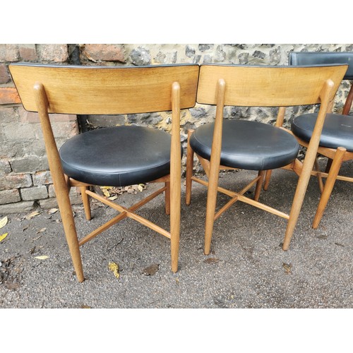 53 - A mid-century teak circular table, together with a set of four G-Plan 'Fresco' black vinyl and teak ... 