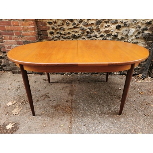 54 - A G-Plan extending dining table together with a set of six G-Plan 'Fresco' black vinyl and teak fram... 