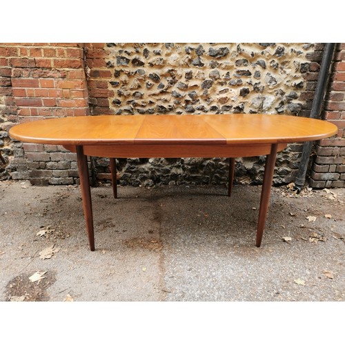 54 - A G-Plan extending dining table together with a set of six G-Plan 'Fresco' black vinyl and teak fram... 