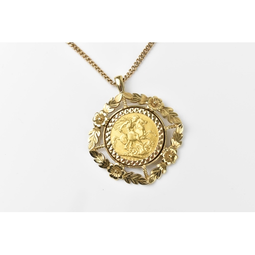 120 - A 9ct yellow gold flat curb link chain necklace with a George V, 1911 sovereign coin in a 9ct gold f... 